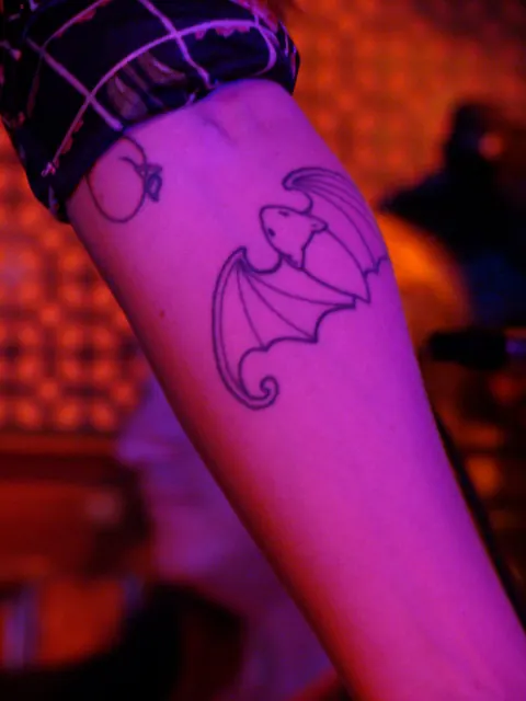 Fresh linework bat tattoo with spread wings on the inner forearm