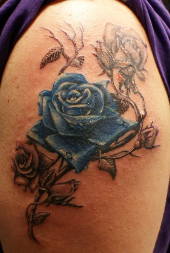 Blue and grey rose tattoo on the shoulder