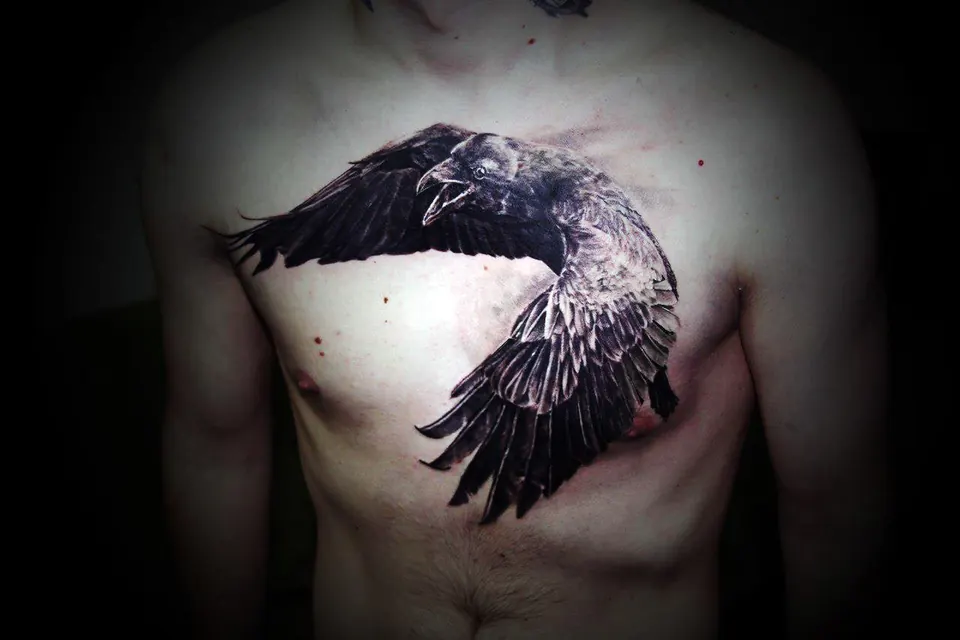 Black crow with spread wings tattooed across the chest
