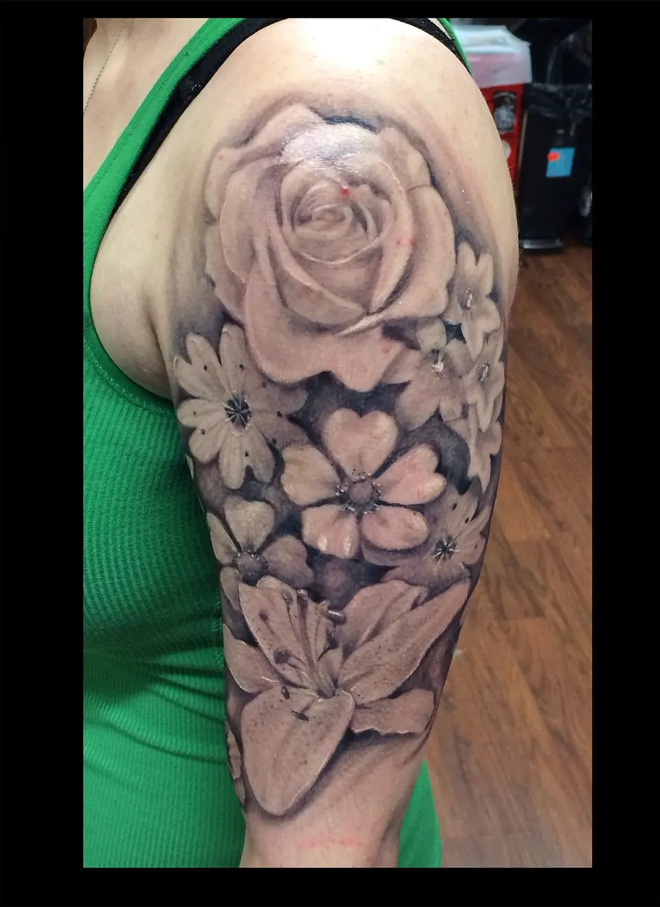 Black and grey realistic rose and flowers tattoo on the shoulder
