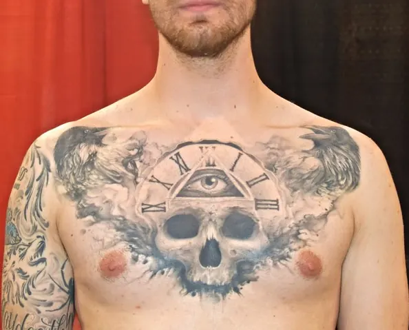 Black and grey chest piece with a skull below an all-seeing eye and clock