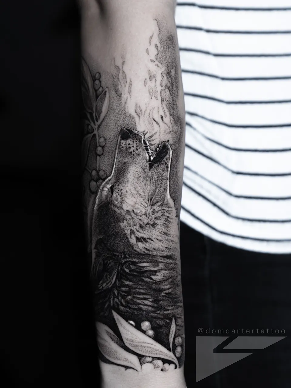 Black and grey wolf tattoo on the forearm