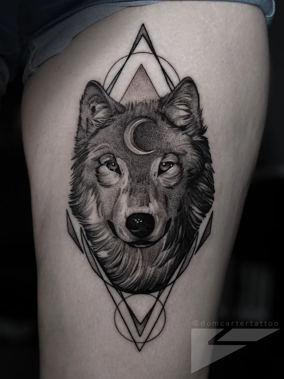 Wolf head tattoo with a crescent moon and geometric frame